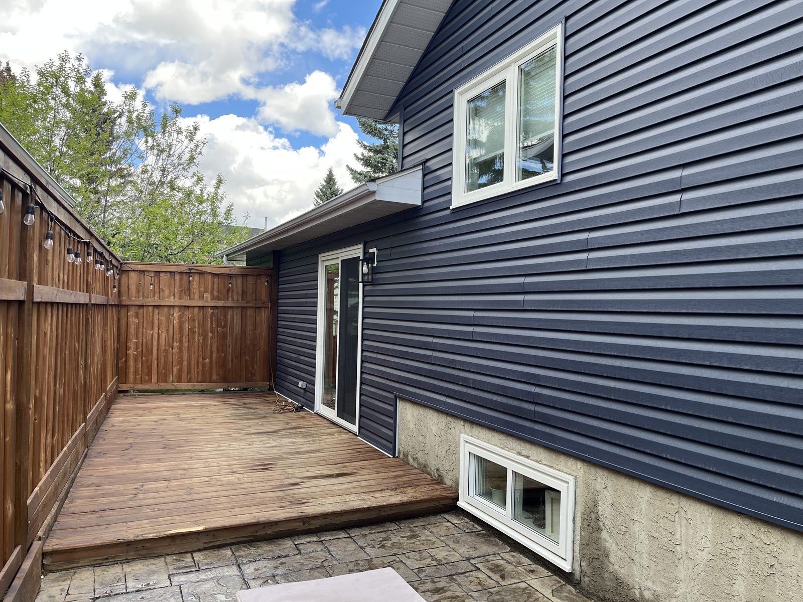 Deck and lower windows of a blue home after a full clean