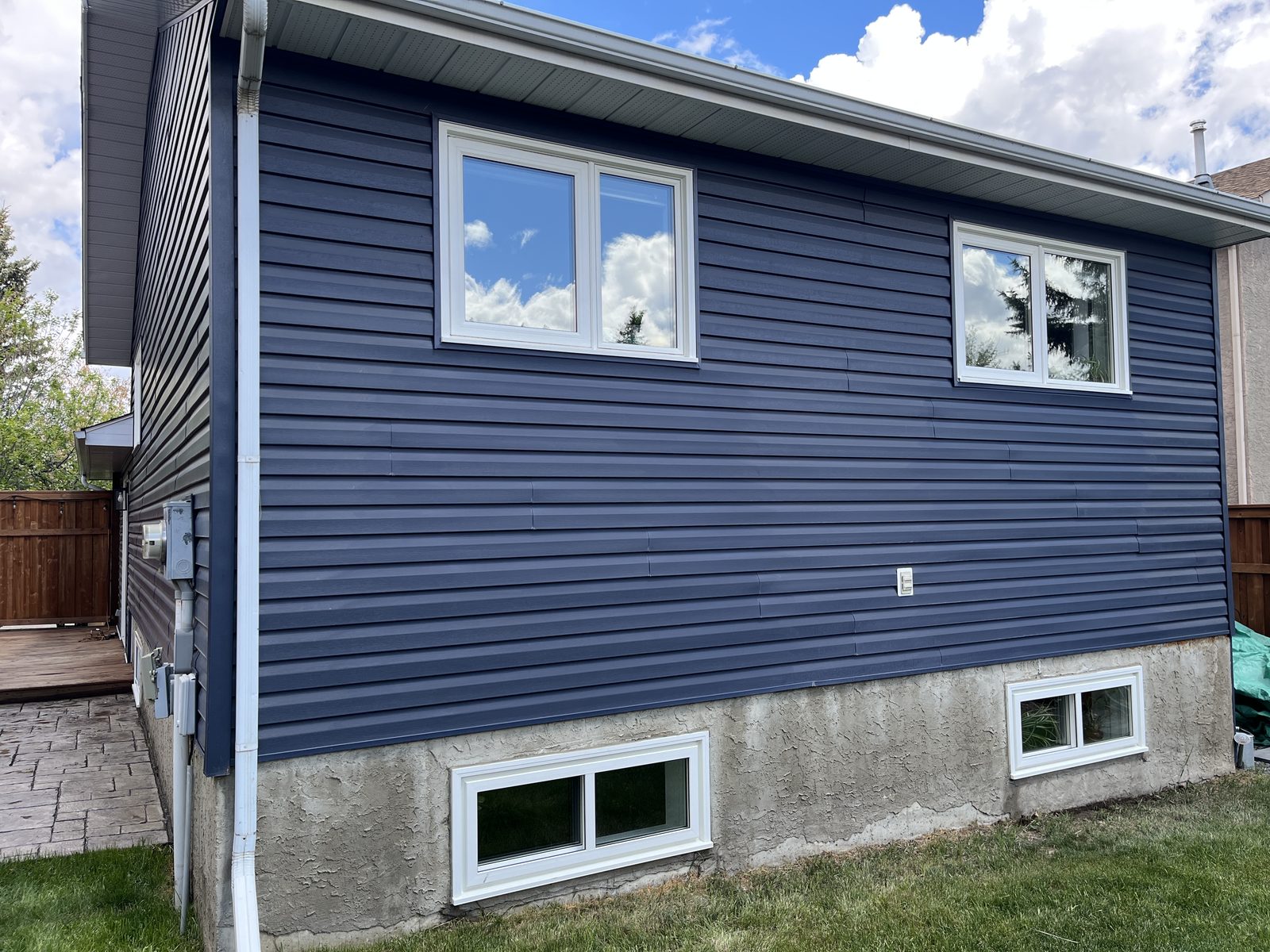 Blue two-storey home with streak-free windows after cleaning
