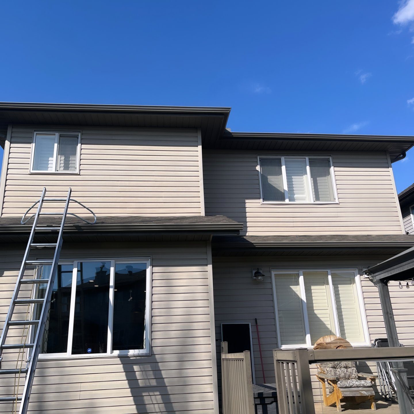 Ladder set on a tight footpath to reach a high side window